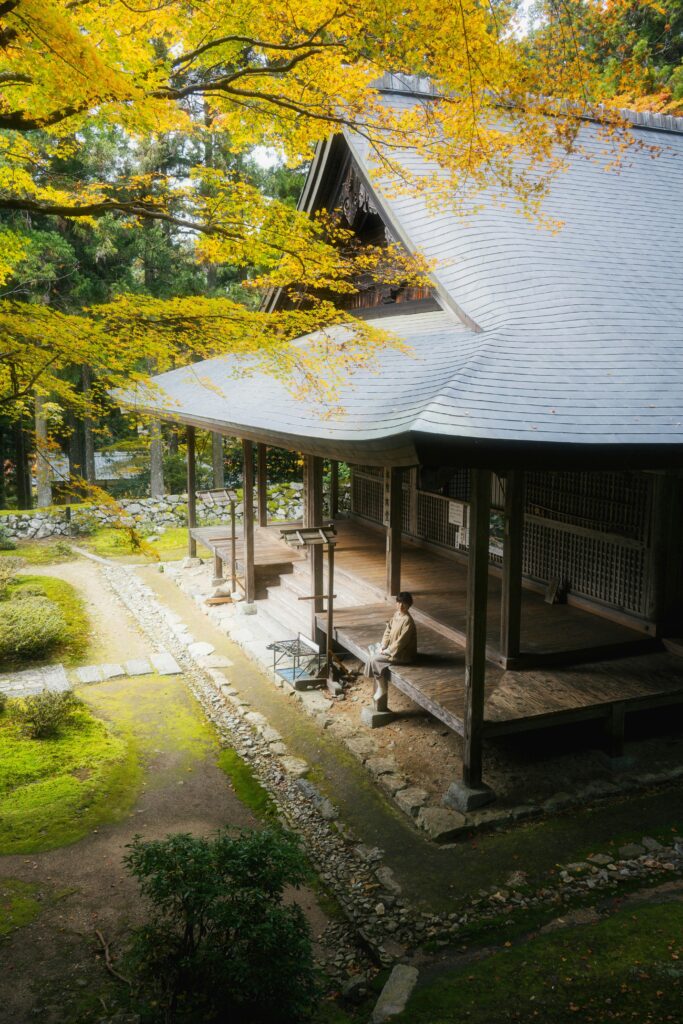 Serene Japanese temple surrounded by vibrant autumn leaves.