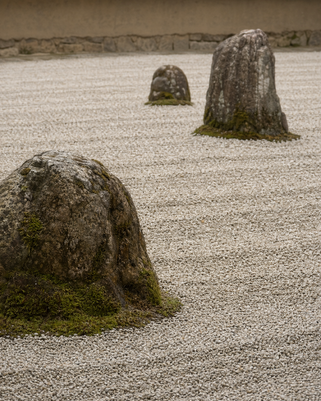 Raked gravel and weathered stones in a Japanese dry garden, viewed from a low angle