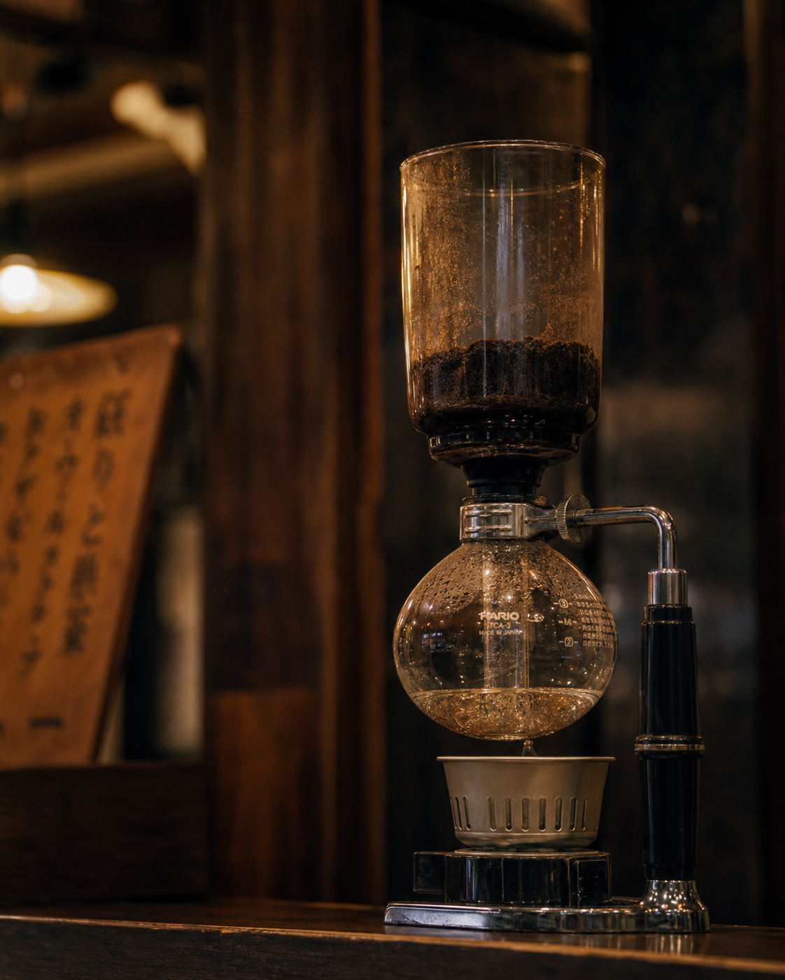 A coffee siphon on a counter in a Japanese jun-kissa — Showa-era brewing equipment
