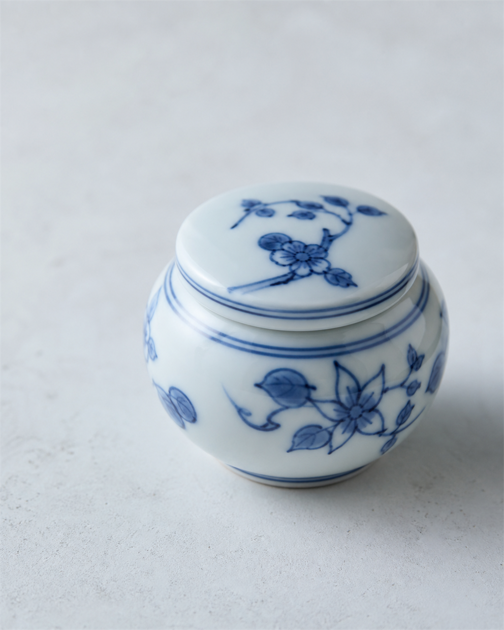 White Japanese porcelain vessel with blue underglaze painting in the Arita style