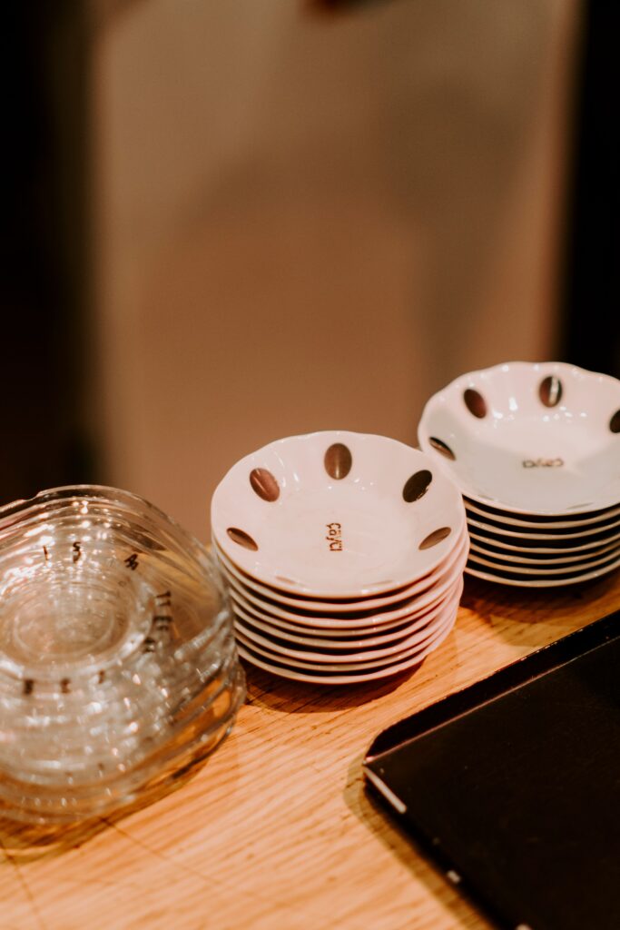 Artistic composition of neatly stacked ceramic and glass bowls on a wooden surface, showcasing texture and light.